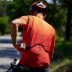 Cycliste vu de dos équipé d'un gilet de vélo coupe-vent orange