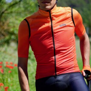 Cycliste équipé d'un gilet de vélo coupe-vent orange
