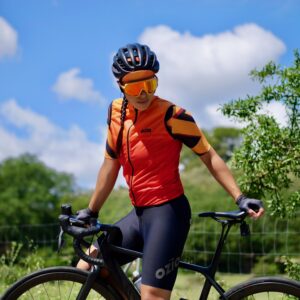 Cycliste femme équipée d'un gilet de vélo coupe-vent orange